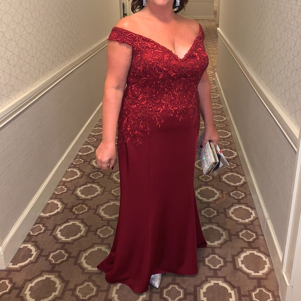 Madeline Gardner Woman’s wine colored off the shoulder evening gown.